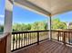 Relaxing back porch with wood floors and rails, providing scenic views of the surrounding trees and blue skies at 538 Sawnee Village Blvd # D67, Cumming, GA 30040