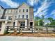 A beautiful townhome exterior showcases brick accents, and a decorative fence, creating curb appeal at 556 Sawnee Village Blvd # D76, Cumming, GA 30040