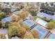 This aerial view highlights the multiple tennis courts, a large swimming pool, and a pond near beautiful neighborhood homes at 6730 Waterbury Way, Cumming, GA 30040