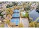 This aerial view shows tennis courts, a pool, a clubhouse, and a small pond near beautiful neighborhood homes at 6730 Waterbury Way, Cumming, GA 30040