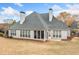 Rear view of home with screened in porch, patio and lush lawn and mature landscaping at 6730 Waterbury Way, Cumming, GA 30040