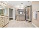 Bright bathroom featuring double vanities, tiled floors, and walk-in glass shower at 6730 Waterbury Way, Cumming, GA 30040