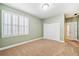 Bright bedroom features plush carpeting, light green walls, and a window with white shutters at 6730 Waterbury Way, Cumming, GA 30040