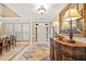 Elegant foyer featuring tile flooring, ornate mirror, and views into the dining room at 6730 Waterbury Way, Cumming, GA 30040