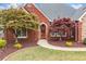 Close-up view of the front entrance with a beautiful brick facade and landscaped garden at 6730 Waterbury Way, Cumming, GA 30040