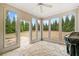 Inviting sunroom with scenic backyard views, stone floors, and ample natural light at 6730 Waterbury Way, Cumming, GA 30040