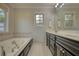 Bright bathroom featuring a soaking tub, dual vanities, and natural light from two windows at 806 Jefferson Sw Ct, Conyers, GA 30094