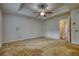 Large bedroom featuring a tray ceiling with fan, and a view into an adjacent room at 806 Jefferson Sw Ct, Conyers, GA 30094