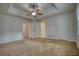 Bedroom with neutral walls, large windows, ceiling fan, and multiple entryways at 806 Jefferson Sw Ct, Conyers, GA 30094