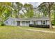 Charming single-story home with light-blue siding, a white front porch, and a well-maintained front yard at 806 Jefferson Sw Ct, Conyers, GA 30094