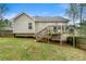 View of the home's backyard, deck, and fenced perimeter from the lawn at 313 Daniel Mill Xing, Villa Rica, GA 30180