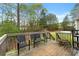 Wooden deck with black metal chairs overlooks the backyard and surrounding wooded area at 313 Daniel Mill Xing, Villa Rica, GA 30180