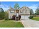 Charming two-story home with stone accents, attached garage, and landscaped front yard at 313 Daniel Mill Xing, Villa Rica, GA 30180