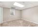 Basement bedroom with carpeted floor, single window, and drop ceiling with fluorescent light at 647 Sunshine Nw Trce, Acworth, GA 30102