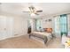 Bedroom featuring a ceiling fan, two windows, carpet flooring, and ensuite bathroom at 647 Sunshine Nw Trce, Acworth, GA 30102