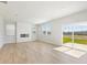 Bright, open living room with fireplace, wood floors, and sliding glass doors at 7194 Brushwood Bend - Lot 116, Lithonia, GA 30058