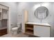 Modern bathroom with floating vanity, round mirror and tile floors next to walk-in closet at 1155 Custer Se Ave # 209, Atlanta, GA 30316