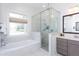 Bright bathroom with glass enclosed shower, soaking tub, and gray vanity at 1515 Walker Ave, Atlanta, GA 30337