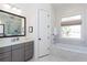 Bright bathroom with glass enclosed shower, soaking tub, and gray vanity at 1515 Walker Ave, Atlanta, GA 30337