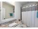Bathroom features granite counters, white cabinets, and a tub-shower with a white and gray shower curtain at 1515 Walker Ave, Atlanta, GA 30337
