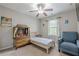 Comfortable bedroom with ceiling fan, large window, and blue chair at 2705 Maple Park Pl # 29, Cumming, GA 30041