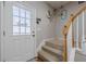 Bright entryway with decorative glass door and stairway with white trim and wood railing at 2705 Maple Park Pl # 29, Cumming, GA 30041