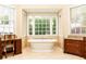 Luxurious bathroom featuring a soaking tub with views, tile flooring, and custom cabinetry at 3022 Loridan Se Way, Atlanta, GA 30339