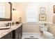 Elegant half bath featuring granite countertops, decorative mirror and neutral color palette at 3022 Loridan Se Way, Atlanta, GA 30339