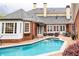 Spacious pool and spa area bordered by brick patio and red brick home featuring multiple white doors and windows at 3022 Loridan Se Way, Atlanta, GA 30339