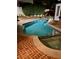 Night shot of rectangular pool surrounded by brick patio with subtle lighting and bordering shrubbery and fence at 3022 Loridan Se Way, Atlanta, GA 30339