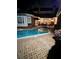 Exterior night view of a brick home featuring a pool, spa, and brick patio with outdoor seating at 3022 Loridan Se Way, Atlanta, GA 30339