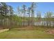 The back yard has a grass lawn and a view of the water surrounded by trees at 3725 Rifflewood Way, Douglasville, GA 30135