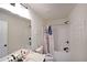 This bathroom has a single vanity, a tub shower with a decorative shower curtain, and art work at 3725 Rifflewood Way, Douglasville, GA 30135
