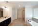 The primary bathroom features a double vanity, soaking tub, tile floors, and glass enclosed shower at 3725 Rifflewood Way, Douglasville, GA 30135
