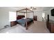 This main bedroom is spacious with a four poster bed, ceiling fan, and a view into the bathroom at 3725 Rifflewood Way, Douglasville, GA 30135
