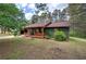The side of the home displays its quaint exterior and inviting front porch with a rustic bird bath at 38 E Boxwood Se Dr, Cartersville, GA 30121