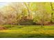 Exterior view from back of property showing home nestled amongst trees and grassy yard at 1919 Wellbourne Ne Dr, Atlanta, GA 30324
