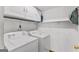 Convenient laundry room featuring a washer, dryer, shelving, and storage space at 5429 Golfcrest Cir, Stone Mountain, GA 30088