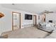 Spacious living room featuring plush carpeting, a ceiling fan, and a large flatscreen television at 5429 Golfcrest Cir, Stone Mountain, GA 30088