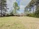 Expansive backyard featuring lush green lawn, mature trees, and room for outdoor activities at 1717 Ramblewood Way, Snellville, GA 30078