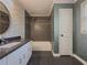 Well-lit bathroom featuring a gray tiled shower and a vanity with a granite countertop at 1717 Ramblewood Way, Snellville, GA 30078