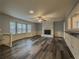 Spacious living room featuring updated flooring, a fireplace, ceiling fan, and natural light from large windows at 1717 Ramblewood Way, Snellville, GA 30078