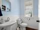 Charming powder room with wainscoting, pedestal sink, and bright window at 4421 Wooded Oaks Nw, Kennesaw, GA 30152