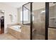 Spa bathroom featuring soaking tub with tile surround and frameless glass shower enclosure at 4421 Wooded Oaks Nw, Kennesaw, GA 30152