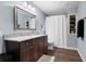 Well-lit bathroom features a granite countertop, a large framed mirror, and a shower with a white curtain at 4421 Wooded Oaks Nw, Kennesaw, GA 30152