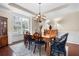 Well-lit dining room with hardwood floors, white wainscoting, and an ornate chandelier above a wooden table at 4421 Wooded Oaks Nw, Kennesaw, GA 30152