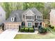 Charming two-story brick home with well-manicured landscaping, a two-car garage, and a welcoming front porch at 4421 Wooded Oaks Nw, Kennesaw, GA 30152