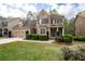 Beautiful two-story home with a brick and siding exterior, green lawn, and mature landscaping at 4421 Wooded Oaks Nw, Kennesaw, GA 30152