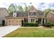 Charming two-story brick home with a well-manicured front yard and an attached two-car garage at 4421 Wooded Oaks Nw, Kennesaw, GA 30152