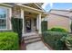 Covered front porch with brick steps and white columns, framed by manicured greenery and decorative shrubs at 4421 Wooded Oaks Nw, Kennesaw, GA 30152